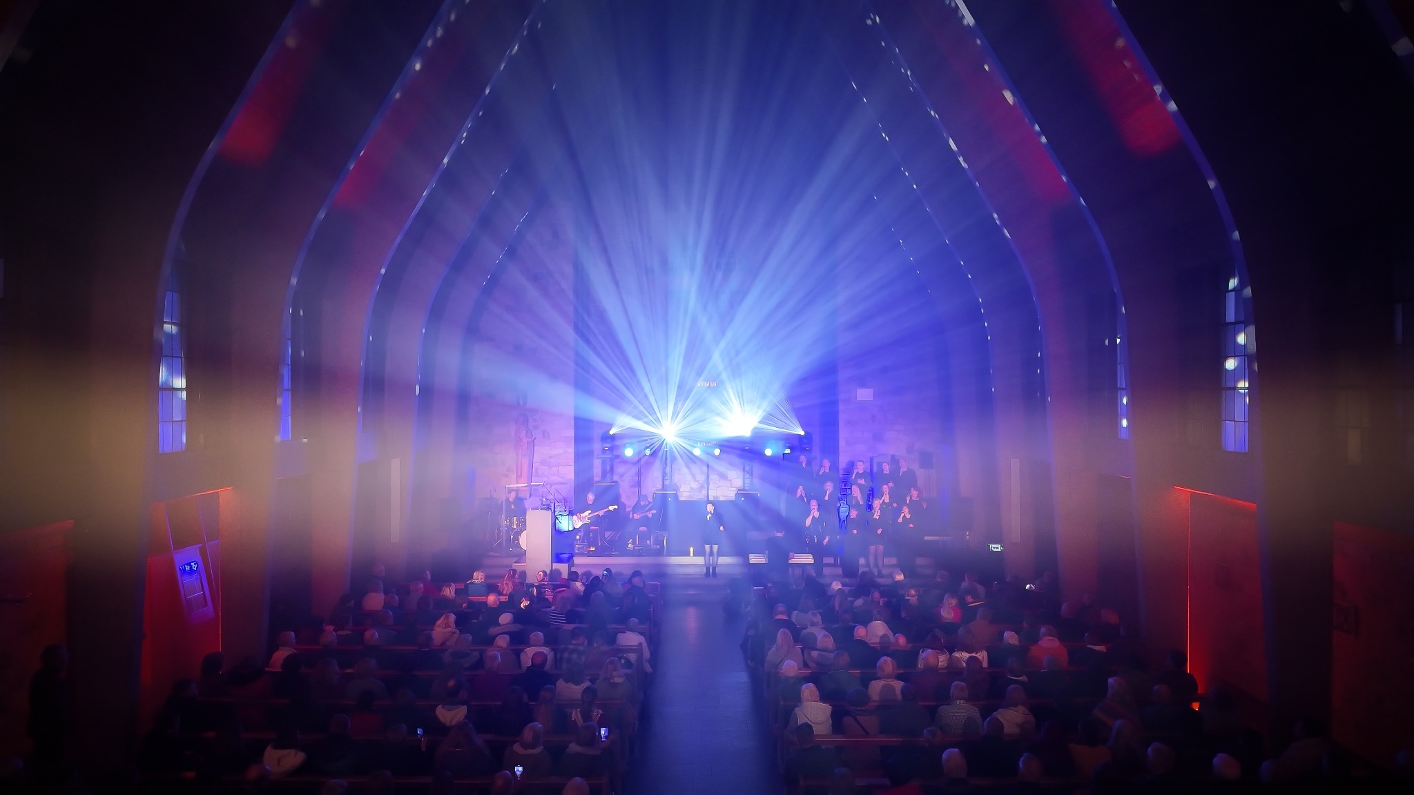 Voices of Worship live in der blau beleuchteten Kirche